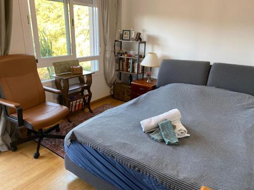 een slaapkamer met een bed, een stoel en een raam bij Hidden Gem Bed& Breakfast Estepona Hills in Estepona