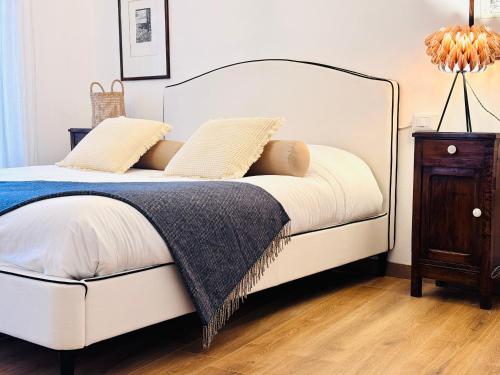 sypialnia z białym łóżkiem i stolikiem nocnym w obiekcie ComeCasa 2 Bedrooms With Garden Apartment w mieście Benevello