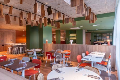 a restaurant with tables and chairs and a bar at The Originals City, Hôtel Alteora, Poitiers Site du Futuroscope (Inter-Hotel) in Chasseneuil-du-Poitou