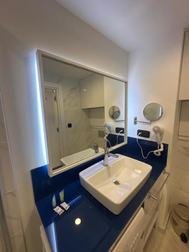 La salle de bains est pourvue d'un lavabo et d'un miroir. dans l'établissement ORBI SITY GOOD VIEW, à Batoumi