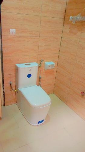 ein WC in einem Zimmer mit einer Holzwand in der Unterkunft Charly-hôtes 02 in Cotonou
