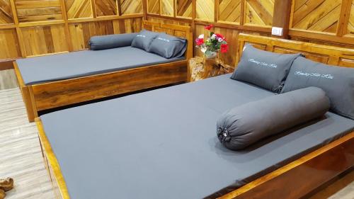 un par de camas en una habitación con flores en Homestay Man Hiếu en Bản Hon