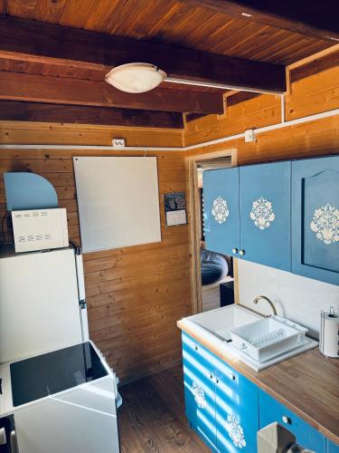 a kitchen with blue cabinets and a counter top at Casutele Suhardul Mic in Lacu Rosu