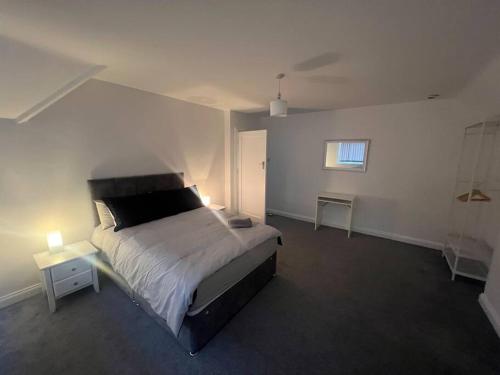 a bedroom with a bed and two tables and a window at House in London near O2, Greenwich & Canary Wharf in Eltham