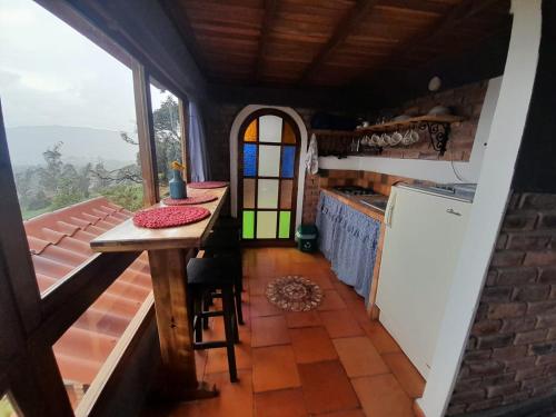 cocina con encimera y mesa en una habitación en Cabaña Mirador, las Acacias de Teli, en Ventaquemada
