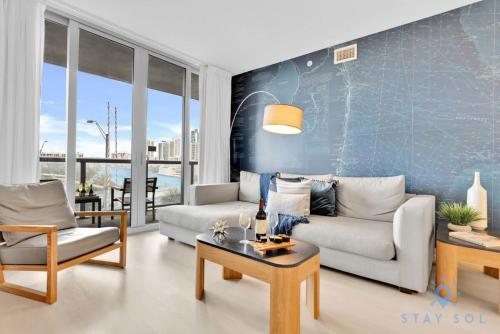 a living room with a couch and a table at Modern Condo - Amazing Pool - Gym - Balcony in Hallandale Beach