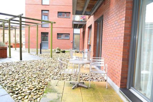 two chairs and a table on a patio next to a brick building at cosy and prime location in Sheffield