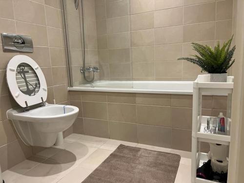 a bathroom with a toilet and a sink and a tub at cosy and prime location in Sheffield