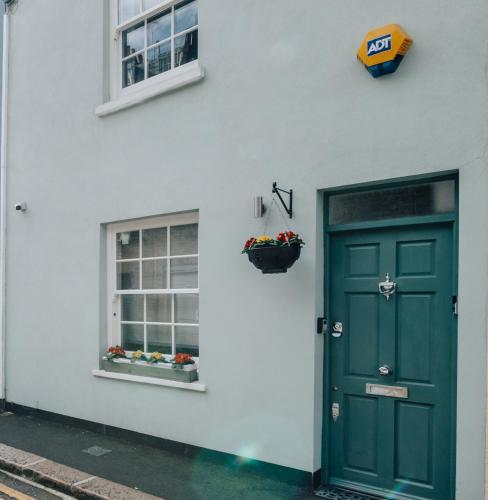 a white building with a green door and a window at Exceptional Whole House Chelsea with Roof Terrace in London