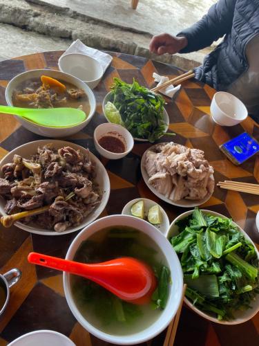 una mesa cubierta con tazones de sopa y verduras en Homestay Man Hiếu en Bản Hon