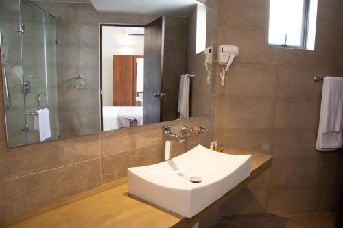 a bathroom with a sink and a shower and a mirror at Marine Suites in Colombo