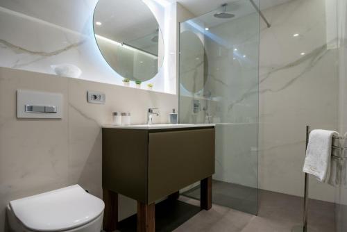 a bathroom with a sink and a toilet and a mirror at Luxury villa Brac Belle Vue with heated pool in Selca