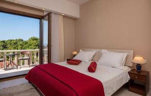 1 dormitorio con 1 cama con almohadas rojas y balcón en Luxury villa Brac Belle Vue with heated pool, en Selca