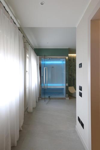 a hallway with white curtains and a blue room at Relais Le Betulle in Conegliano
