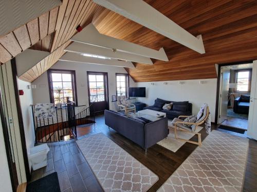 a living room with a couch and wooden ceilings at Annas Ställe B&B in Byxelkrok