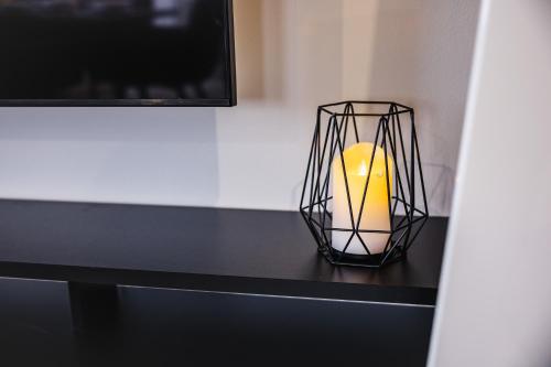 a candle sitting on a black table next to a tv at Rezidence Petra Voka in Třeboň