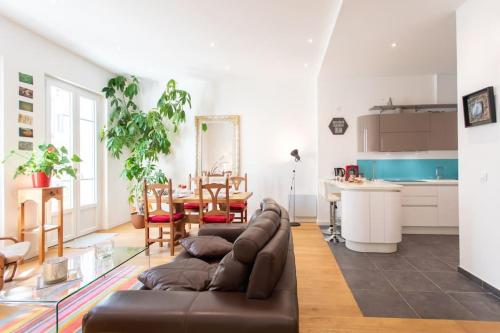 un salon avec un canapé marron et une table dans l'établissement #22 Emma Suite 2BDR Balcony center town 2mins tramway, à Nice