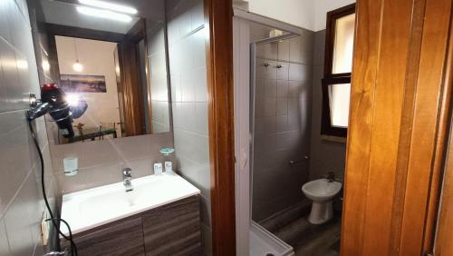 a bathroom with a sink and a mirror and a toilet at Residence Ristorante Il Paradiso in Guardistallo