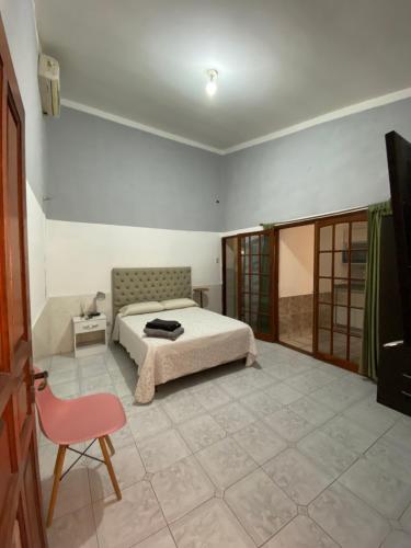 um quarto com uma cama e uma cadeira vermelha em Miel em Tinogasta