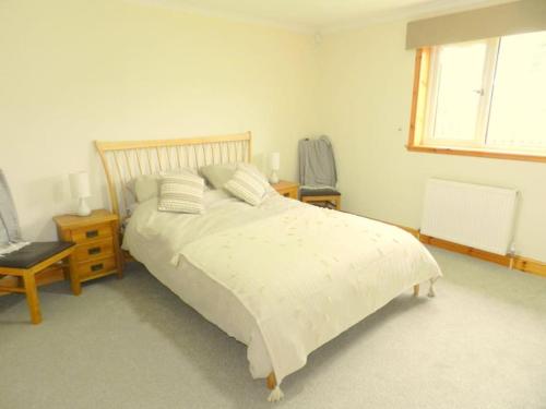 a bedroom with a bed and a chair and a window at Annexe Meadowbank Dumfries in Dumfries