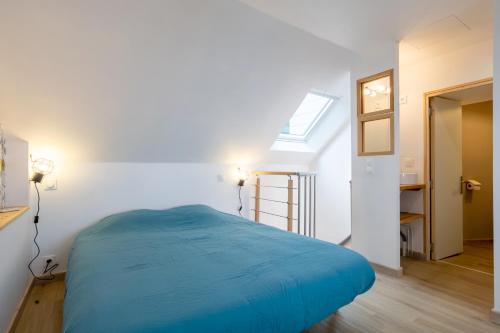 um quarto com uma cama azul num quarto em Duplex de charme em Le Guilvinec