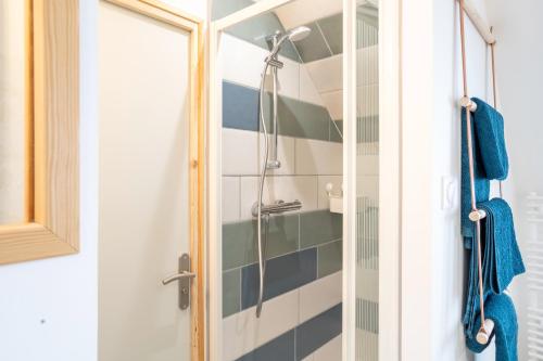 um chuveiro com uma porta de vidro na casa de banho em Duplex de charme em Le Guilvinec