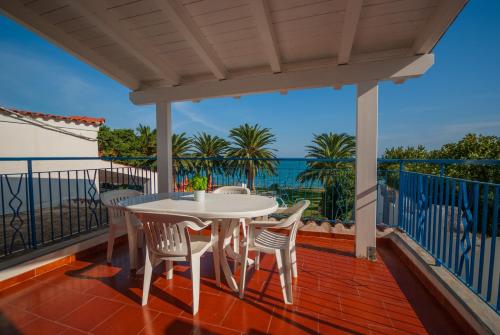 una mesa y sillas en un balcón con vistas al océano en Villa Lucia, en Mattinata