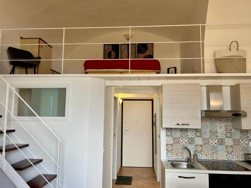 - une cuisine avec des placards blancs, un évier et un escalier dans l'établissement Sperlonga Paradise Central Loft, à Sperlonga