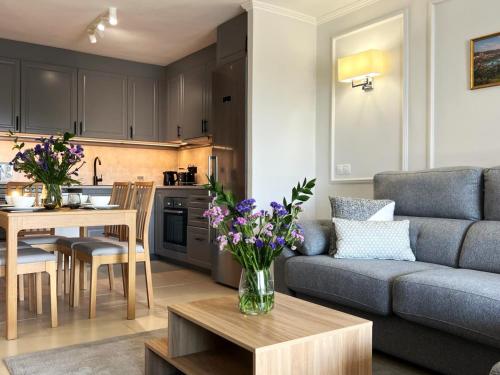 un soggiorno con un divano e un tavolo con fiori di Apartamento Amarillo Oceanview a Playa Fañabe