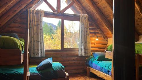 um quarto com 2 beliches num chalé de madeira em Los Nires Lodge Cerro Catedral em San Carlos de Bariloche