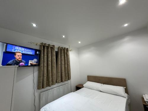 1 dormitorio con 1 cama y TV en la pared en Beautiful Double Room with Free Wi-Fi and free parking en Lewisham