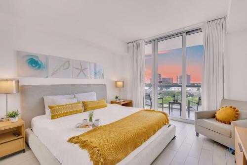 a white bedroom with a large bed and a window at Amazing Pool - Balcony - Gym - Near Beach in Hallandale Beach