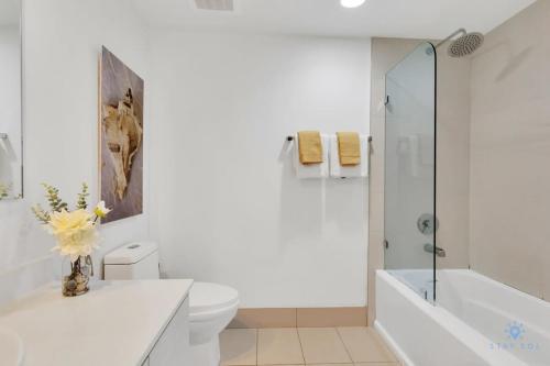 a white bathroom with a toilet and a shower at Amazing Pool - Balcony - Gym - Near Beach in Hallandale Beach