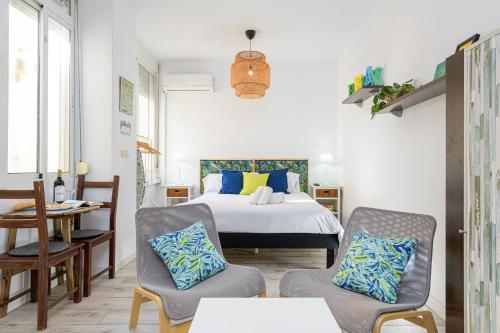1 dormitorio con 1 cama, 2 sillas y mesa en WintowinRentals Estudio Interior Málaga Centro, en Málaga