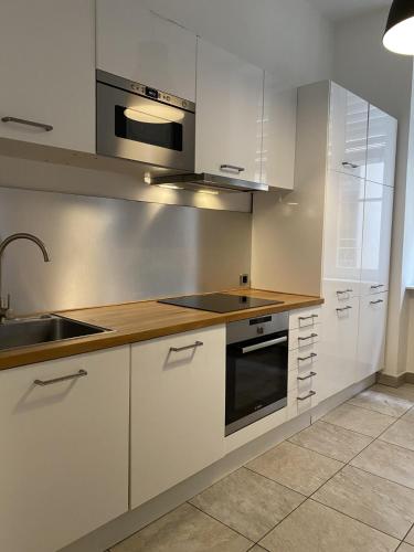 a kitchen with white cabinets and a sink at Chambre confort centre ville chez l'habitant in Lyon