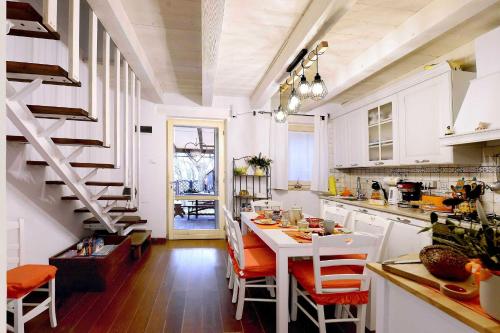 une cuisine avec une table et des chaises ainsi qu'un escalier dans l'établissement Lillac Cottage, à Ancône