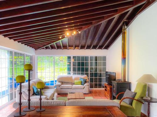 un soggiorno con un divano e una TV di WelcomeBuddy - Casa Tia Néné - Green Glassyard a Lagoa