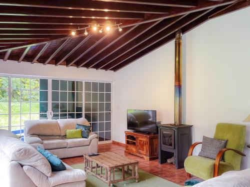 a living room with a couch and a tv at Casa Tia Néné - Green Glassyard in Lagoa