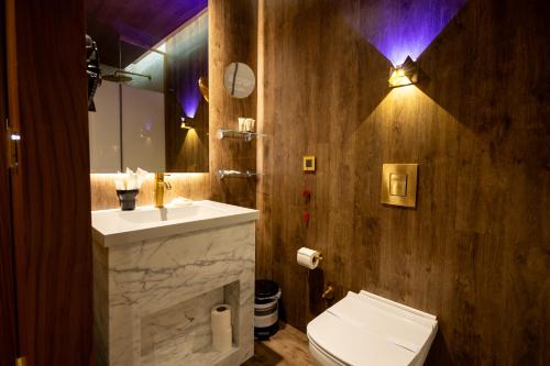 a bathroom with a sink and a toilet and a mirror at Kate Hotel Special Class & SPA in Istanbul