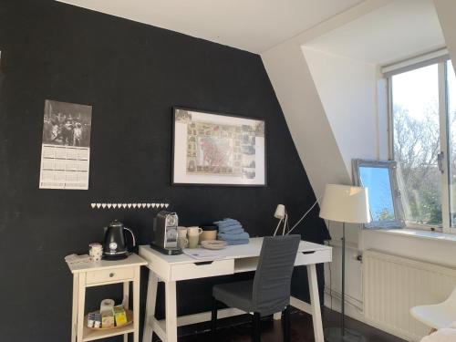 einen Schreibtisch in einem Zimmer mit einer schwarzen Wand in der Unterkunft Van der Welle - Ndd in Amsterdam