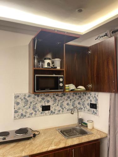 a kitchen with a sink and a microwave at One Aquarium Inn in Cape Coast