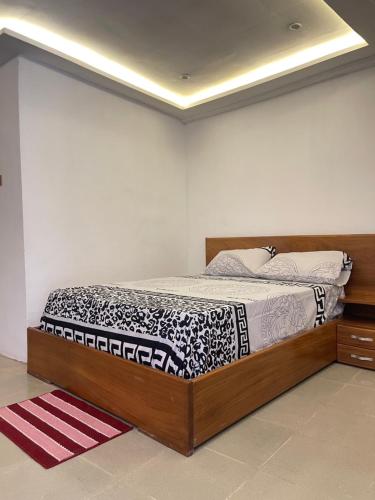 a bedroom with a bed with a black and white comforter at One Aquarium Inn in Cape Coast