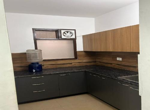 a kitchen with black cabinets and a counter top at Akshay dream stay in Gurgaon