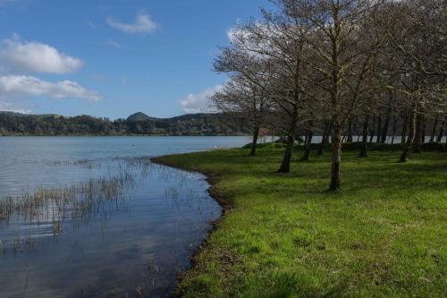 a body of water with trees on the side of it at Quinta D'Água in Furnas