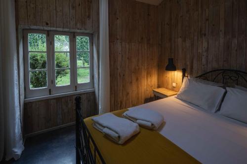 a bedroom with a bed with two towels on it at WelcomeBuddy - Quinta D'Água in Furnas