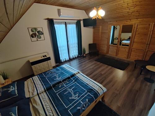 a bedroom with a bed and a wooden floor at Lovas Vendégház in Tiszafüred