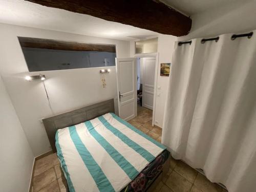 une petite chambre avec un lit dans une pièce dans l'établissement La Garde Freinet -Appartement avec terrasse, à La Garde-Freinet