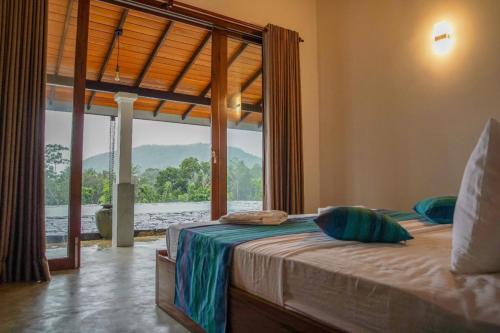 a bedroom with a bed with a large window at Plantation Villa in Baddegama