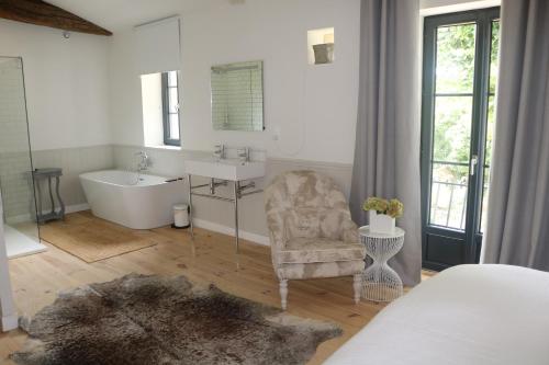 La salle de bains est pourvue d'une baignoire, d'un lavabo et d'une chaise. dans l'établissement The Old Stables, à Saint-Jean-dʼAngély
