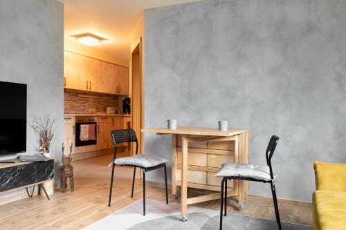 ein Wohnzimmer mit einem Tisch und 2 Stühlen in der Unterkunft Gemütliche Ferienwohnung mit Terrasse und Bergblick in Inzell